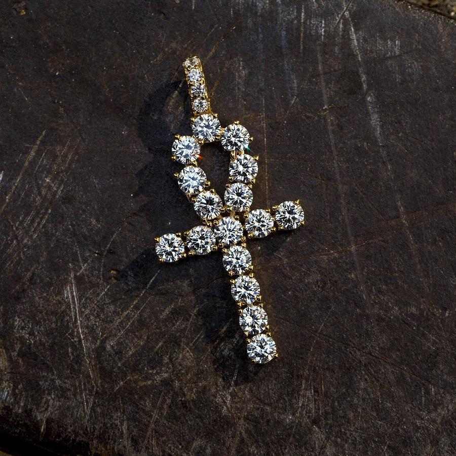 . 3/4 Inch Ankh Cross made up of large CZ stones and yellow gold plated lying flat on a black surface. 