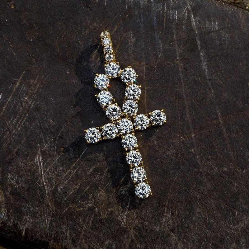. 3/4 Inch Ankh Cross made up of large CZ stones and yellow gold plated lying flat on a black surface. 